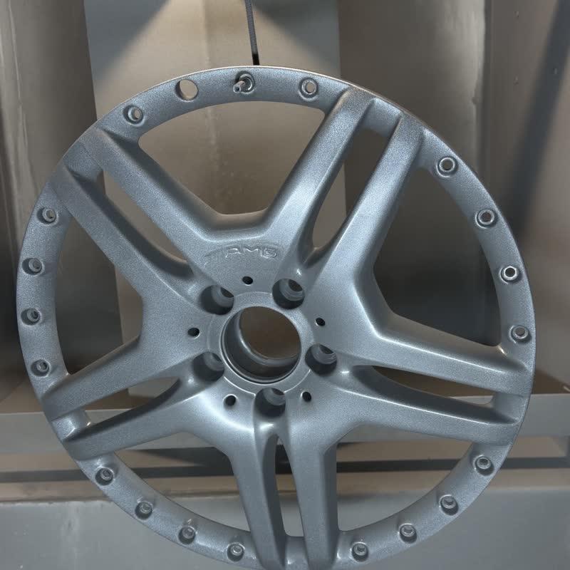Jantă AMG cu buză nituită, suspendată în cabina de vopsit